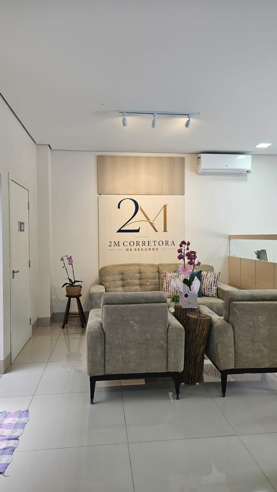 Recepção da 2M Corretora com sofá e painel da marca